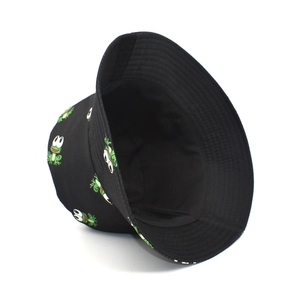 Detail of black bucket hat featuring green cartoon frog patterns on cotton fabric