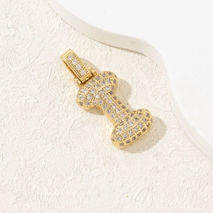 Macro detail of a gold-plated letter pendant with shimmering cubic zirconia pavé setting