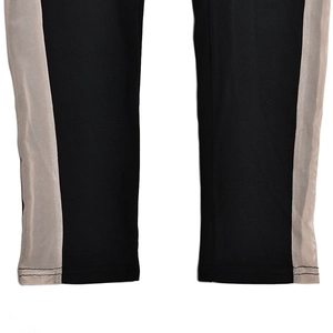 Close-up of black shapewear trousers featuring beige mesh side panel stitching detail