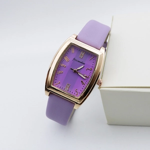Detailed close-up of rose gold tonneau watch case with purple striped dial and leather strap