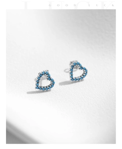 Vue macro de boucles d'oreilles cœur en argent S925 avec turquoise sur fond blanc