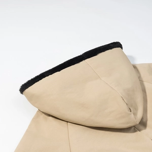 Detail of khaki hooded parka featuring soft black faux fur trim on the hood edge