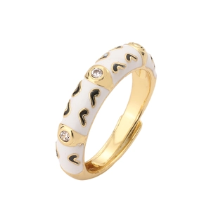 Detailed macro view of white enamel heart ring with gold plating and sparkling zircon stones