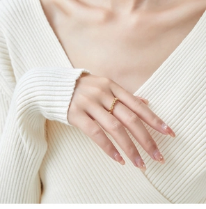 Detail of a minimalist gold hollow ring set with honeycomb geometric pattern on a model