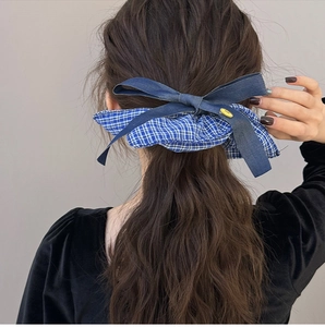 Detailed back view of a blue checkered scrunchie with a denim bow on a high ponytail