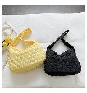 Detailed flat lay of quilted puffer hobo bags in yellow and black with floral accents