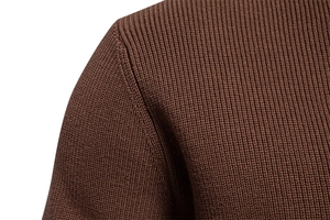 Detail of brown knit sweater showing shoulder seam stitching and soft fabric texture