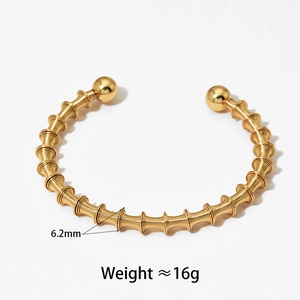 Détail d'un bracelet jonc en acier de 6,2 mm avec spirales et boules dorées polies