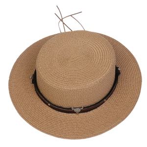 Detail showing the flat straw hat top with leather band and metal bull head emblem