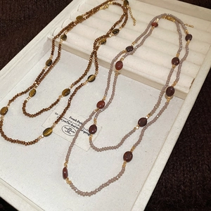 Detailed close-up of ethnic tiger eye beaded necklaces in bohemian and vintage style
