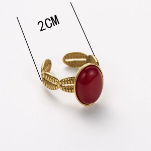 Close-up of vintage gold ring featuring a 2cm oval red stone and woven texture