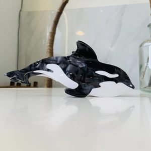 Detail view of orca-shaped acetate hair claw clip with black and white marble texture