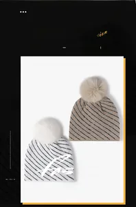 Detail of striped knitted beanies with soft fleece lining and fluffy faux fur pom poms