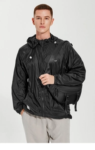Detailed view of a black nylon tactical crossbody chest bag worn on a black parka jacket
