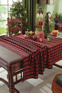 Close-up of red and black plaid Christmas tablecloth with gold silk tassel detail