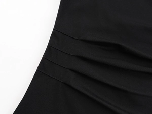 Détail des coutures froncées et texture plissée sur ce haut noir à épaules dénudées