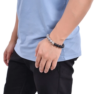 Detailed view of beaded tiger eye bracelet featuring a metallic helmet bead on a male wrist