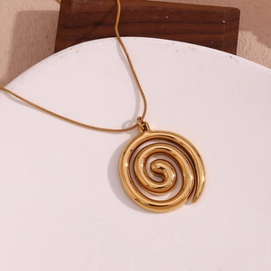 Macro shot of gold spiral pendant on a sleek snake chain with high polished finish