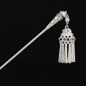 Detail of silver Miao hair pin featuring hollow carvings and jingling tassels on black