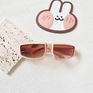 Detail view of pink Y2K sports sunglasses for kids with geometric frame and brown lenses