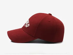 Side view of burgundy baseball cap featuring white embroidered letters and twill cotton texture