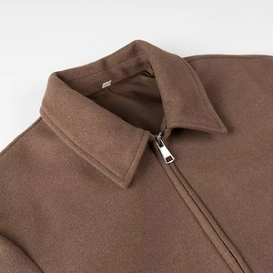 Détail de la texture de veste en laine marron avec col à revers et fermeture éclair