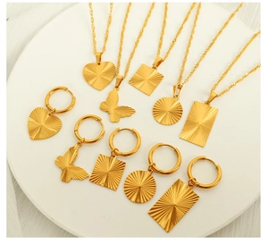 Detailed macro view of 18K gold plated heart and butterfly pendant set with radial texture
