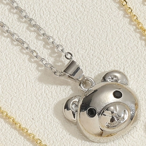 Close-up of cute silver bear pendant necklace with polished finish and snake chain details