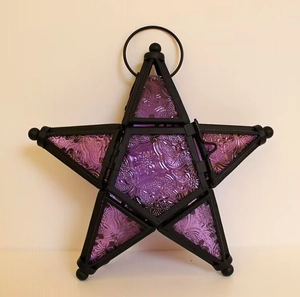 Detail of star-shaped Moroccan lantern with purple textured glass and black metal frame