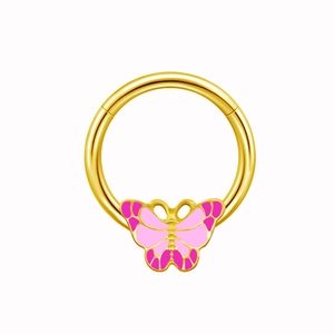 Détail d'un piercing de téton papillon doré avec des ailes roses et un anneau en acier