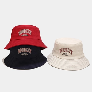 Detail of Brooklyn 1898 embroidery on cotton bucket hats in red, navy and beige