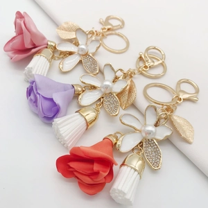 Close-up of fabric floral keychains with rhinestone tassels and golden charms