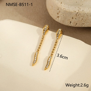 Detail of gold snake-style drop earrings with sparkling cubic zirconia on stone tray