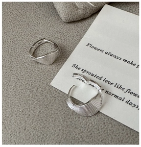Close-up of S925 sterling silver earrings with textured seashell pattern and hallmark