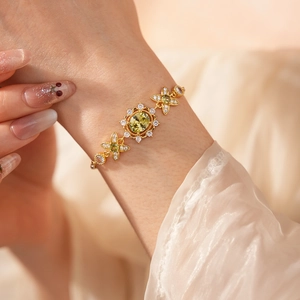 Détail d'un bracelet vintage doré orné d'un zircon jaune ovale et de motifs floraux