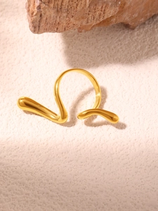 Macro view of fluid abstract golden ring featuring irregular lines and droplet ends