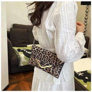 Detailed side view of leopard print envelope bag with gold V-metal trim and chain strap
