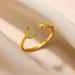 Macro shot of 18K gold plated sun and moon open ring on premium satin fabric texture