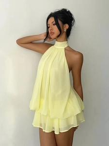 Detail of light yellow chiffon halter neck dress with layered babydoll style ruffles
