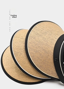 Close-up of woven straw sun visor with black trim showing fine material texture