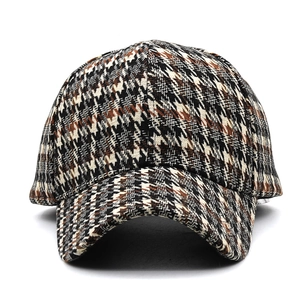 Detailed view of thick houndstooth baseball cap fabric with black and brown woven texture