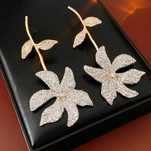 Detailed close-up of crystal flower stud earrings set in a black jewelry gift box