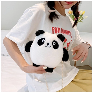 Close-up of a cute plush panda shoulder bag with a metal chain strap on a model