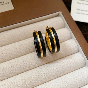 Close-up of leopard print round earrings with gold and black finish in a velvet box