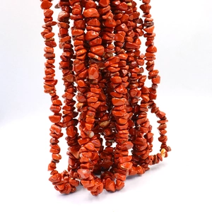 Close-up of natural red crushed stone beads with polished texture for DIY jewelry making