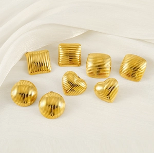 Macro shot of assorted gold geometric stud earrings with textured vertical ripple patterns
