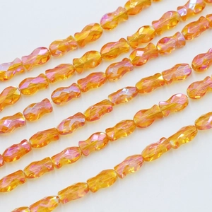Macro shot of 6x10mm orange AB crystal fish beads for DIY jewelry making and phone charms