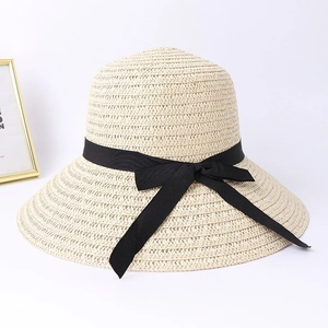 Women's foldable beige straw sun hat with large brim and elegant black ribbon bow
