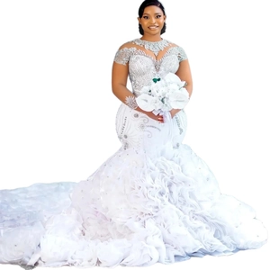 Elegant white mermaid bridal gown with intricate lace embroidery and tiered ruffle train