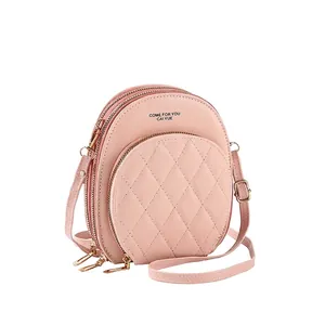 Pink quilted crossbody bag with three zipper compartments and gold hardware detail